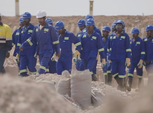 Group of people wearing blue boiler suits and hard hats