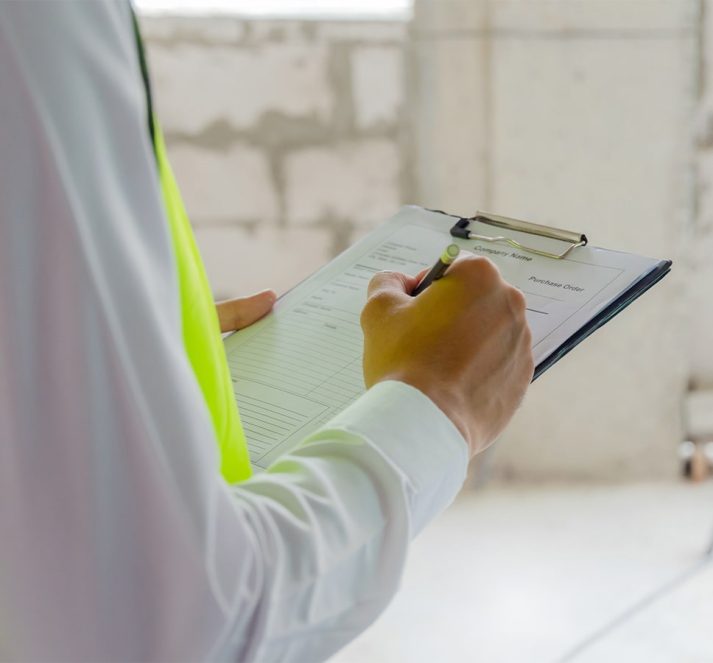 Person wearing a hi-vis jacket holding a clipboard and pen