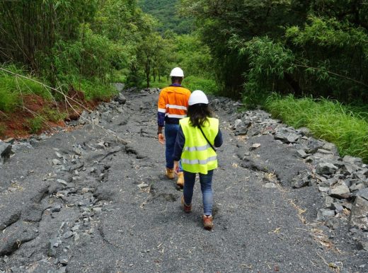 Male and female worker walking down a rocky pathway with trees and plants either side of the path