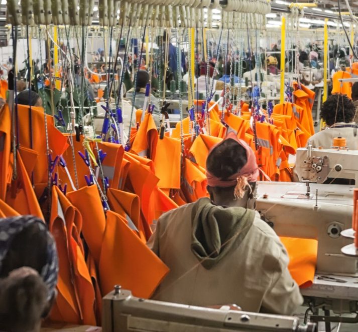 Clothing factory, creating orange fabric, all hung up down the middle