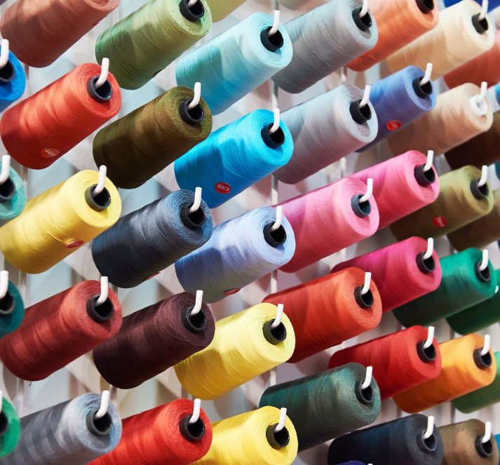 Reels of coloured threads attached to hooks on the wall