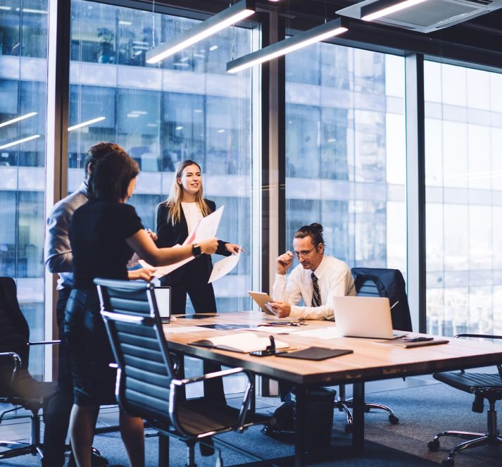 Office scene, people around a desk read through documents