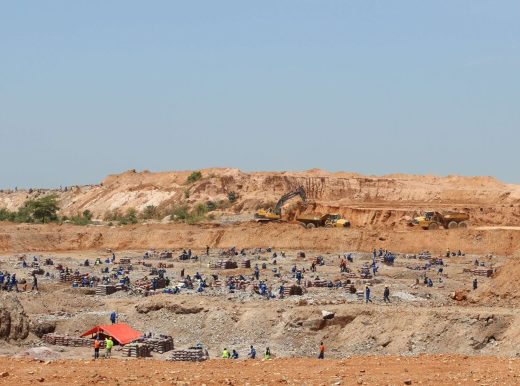 Large mining site, with multiple workers across the landscape