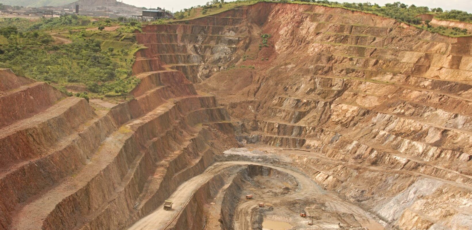Large mining quarry with trees and grass at the top