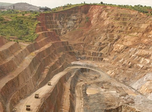 Large mining quarry with trees and grass at the top