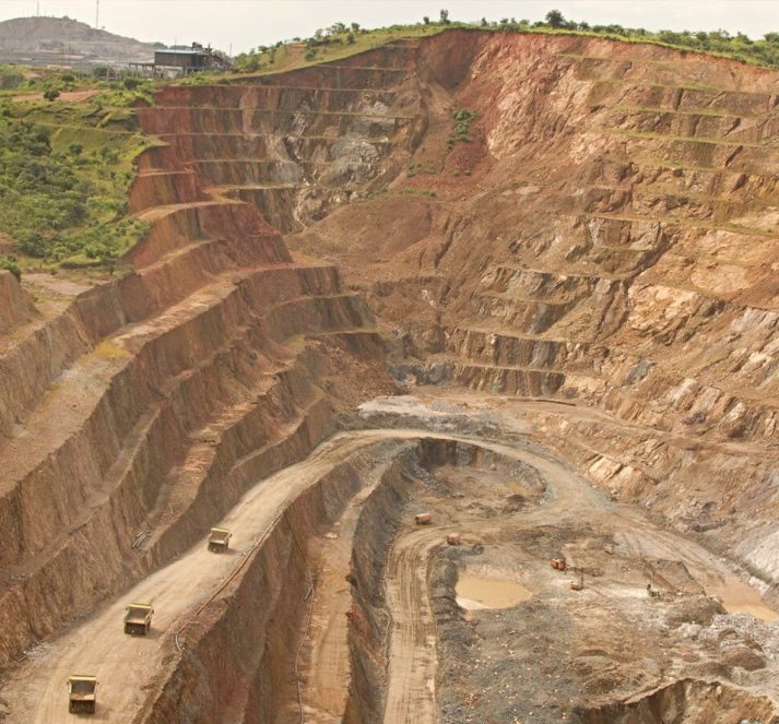 Large mining quarry with trees and grass at the top