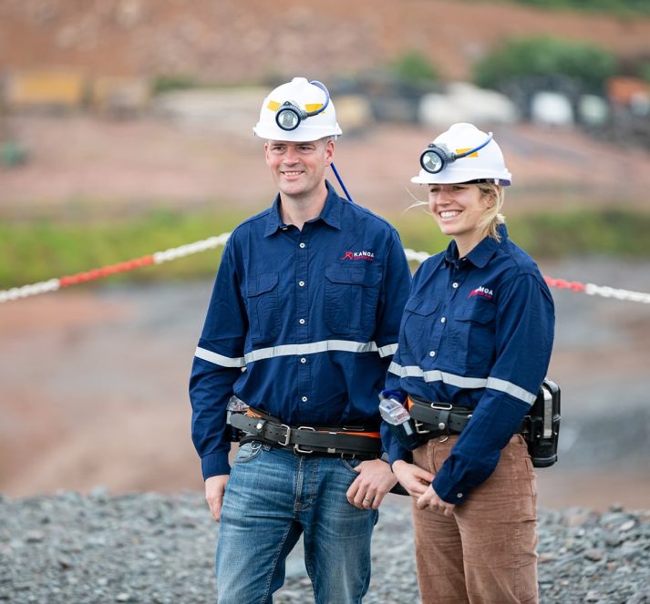 Andrew Britton and Fiona Hutmacher wearing hardhats with lights on site