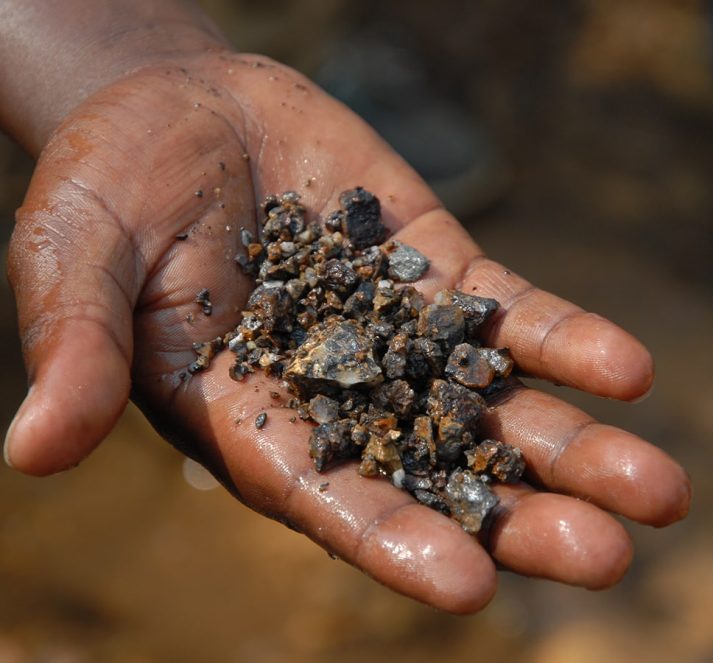 Wet hand holding minerals and small rocks