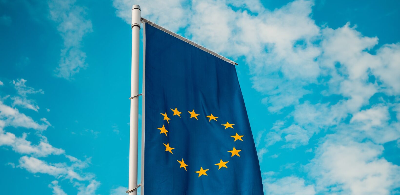 European Union flag with blue cloudy sky background