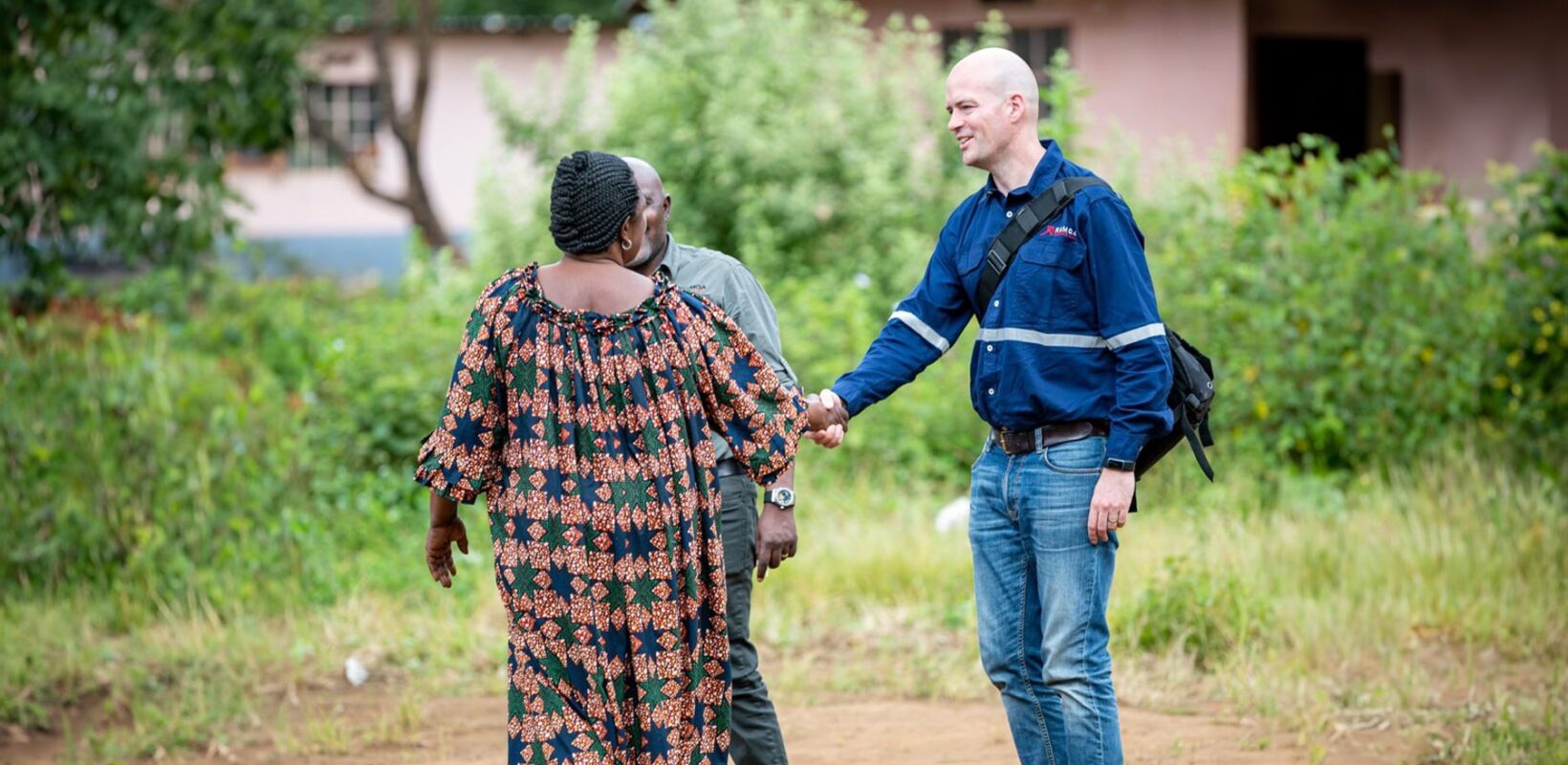 Andrew Britton shaking hands with woman in dress.