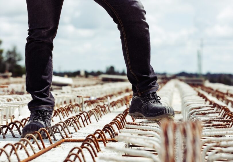 Close-up,Of,A,Construction,Worker,Wearing,Black,Safety,Shoes,Walking